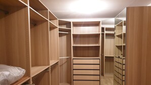 Un dressing avec des étagères en bois, des tiroirs et une section avec un miroir.
