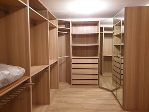 Un dressing avec des étagères en bois, des tiroirs et une section avec un miroir.