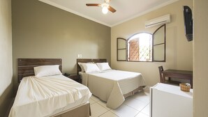 A bedroom with two beds, a desk, and a ceiling fan. - Hotel Recreio dos Bandeirantes (Sertaozinho)