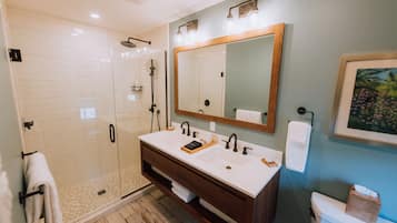 A modern bathroom with a glass-enclosed shower, a double sink vanity, and a large mirror.