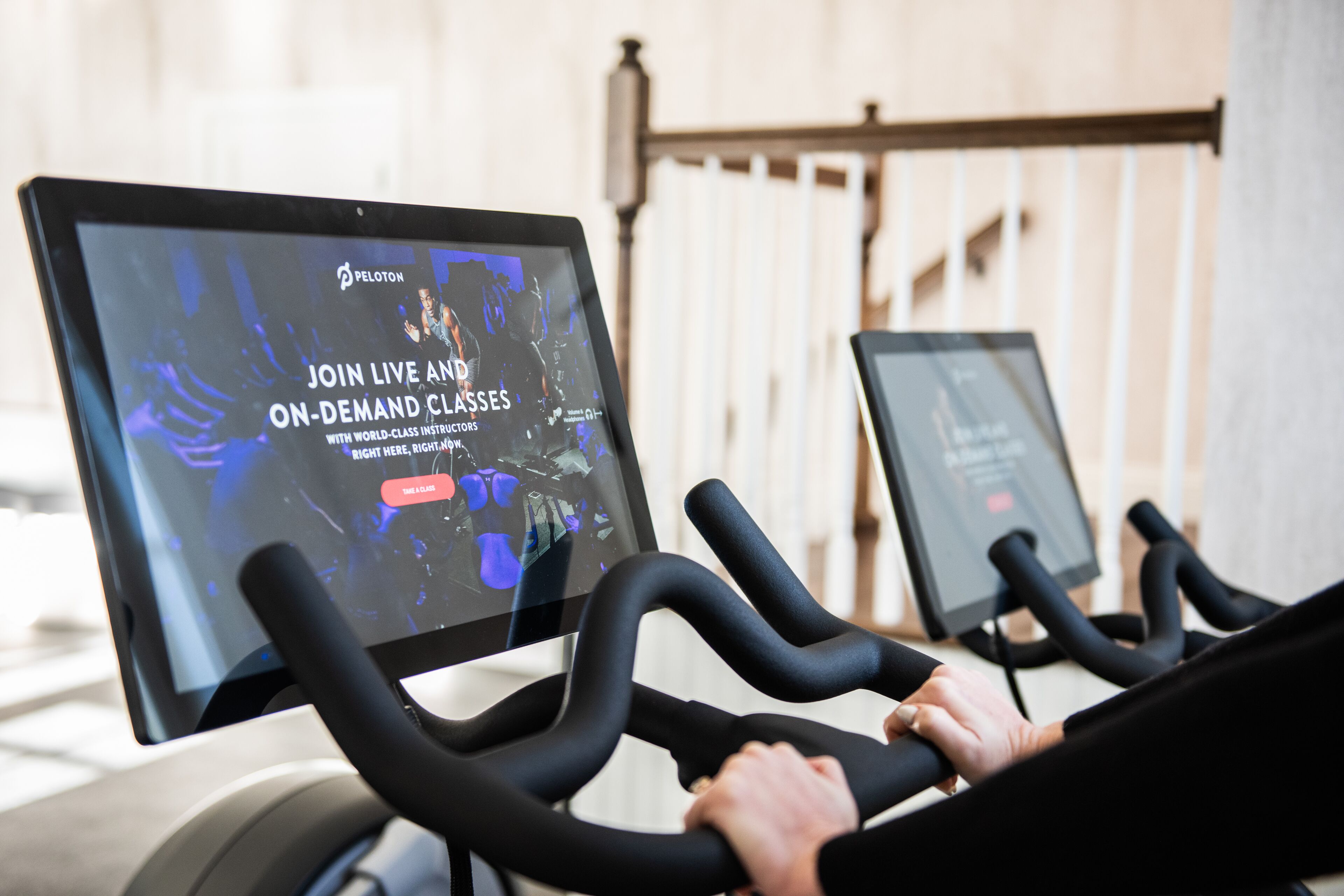 A stationary bike with a screen displaying an advertisement for Peloton classes.