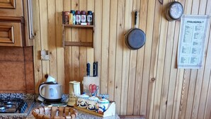 Une cuisine avec des meubles en bois, un plan de travail en granit et divers ustensiles de cuisine.
