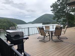 A deck with a grill, chairs, and a table overlooking a lake with hills in the background. - Best Dam View at Smith Mountain Lake!!! (Huddleston)