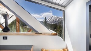 A room with a large skylight overlooking a snowy mountain.