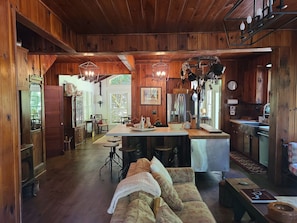 Un intérieur rustique en bois, avec un îlot central, des meubles en bois et un coin salon confortable.