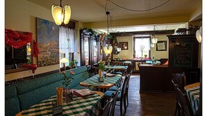 A restaurant with checkered tablecloths, wooden chairs, and hanging light fixtures. - Zum kleinen Reichstag (Moers)