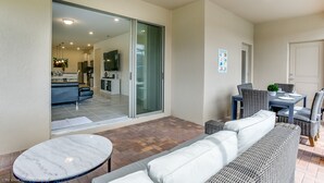 A spacious patio area with a dining table and chairs, a sofa, and a small round table. - Luxury and Style! BIG Pool Area and Game Room in Solterra 6br/4.5 Bath #7st564 (Davenport)