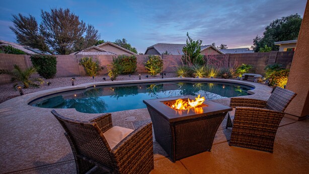 A swimming pool with a fire pit and wicker chairs. - Goodyear, AZ full home with heated pool and spa and desert oasis back yard!! (Goodyear)