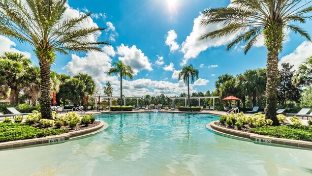 A swimming pool with a 6-inch depth marker, surrounded by palm trees and lounge chairs. - Gorgeous Mediterranean Style Pool/spa Home, Only Minutes From Disneyworld #4wr183 (Davenport)