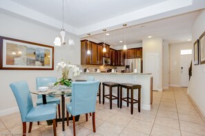 A modern kitchen with wooden cabinets, a central island, and pendant lighting. - Championsgate Town Home Near Top Golf Courses and Disney - 3bd/2.5 Bath #3213 (Davenport)
