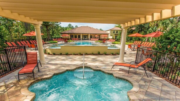 A pool area with lounge chairs and a covered section. - Championsgate Town Home Near Top Golf Courses and Disney - 3bd/2.5 Bath #3213 (Davenport)