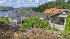 Une propriété située sur la côte, comprenant plusieurs chalets, une terrasse en bois et une vue sur la mer.