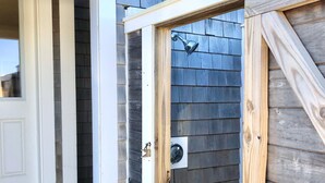 A wooden door with a window above it, a small outdoor step, and a white door frame. - Lovely Oceanview 2 Bed 2 Bath with sleeper sofa, outdoor shower & rooftop deck! (North Truro)