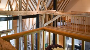 A high ceiling with exposed wooden beams and a metal railing. - 3 bedroom accommodation in Ashdon, near Saffron Walden (Ashdon, near Saffron Walden)