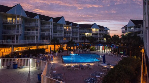 Ein Hotel mit mehreren Balkonen, einem Schwimmbad und Außenbereichs-Sitzgelegenheiten.