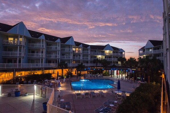 A hotel with multiple balconies, a swimming pool, and outdoor seating areas. - Beachside~Sunrise-Ocean View, Top Fl, Prvt Beach Access, Pool, W&D, Parking (Galveston)