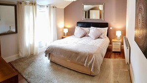 A bedroom with a bed, bedside lamps, a mirror, and a radiator. - Light, airy & spacious room. Centrally located (Portsmouth)