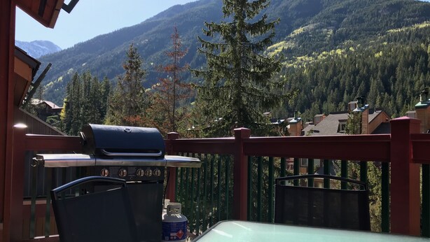 A balcony with a grill, a table, and a chair. - Panorama Horsethief Lodge 2 bedroom condo, Sleeps 6: Unit 516 (Panorama)