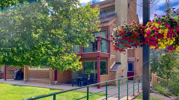 Un bâtiment doté d’un balcon, d’un espace extérieur aménagé pour s’asseoir et d’une jardinière suspendue.