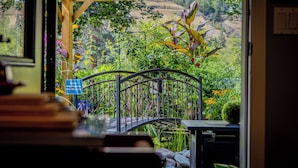 A wooden pergola with a metal bridge over a garden. - Rayleigh Riverfront Retreat -BEAUTIFUL GARDEN OASIS (Kamloops)
