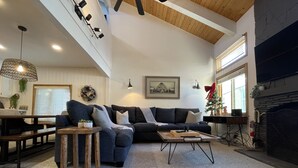 Ein modernes Wohnzimmer mit einer Eckcouch, einem Couchtisch und einem Kamin.