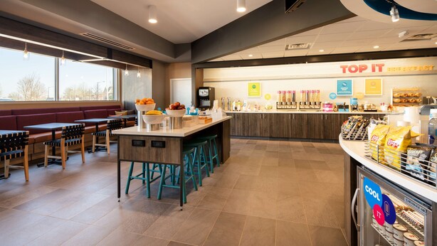 A modern breakfast area with seating, a counter with snacks, and a view of the outside.