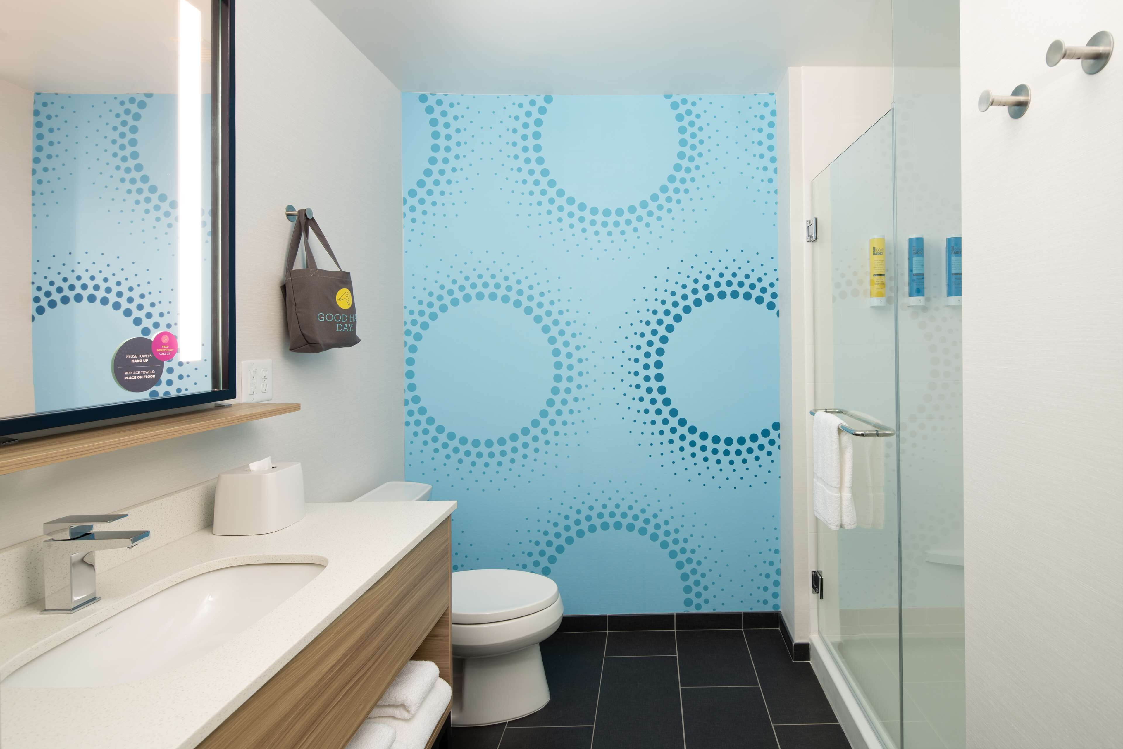 A modern bathroom with a white sink, a toilet, and a glass shower enclosure.