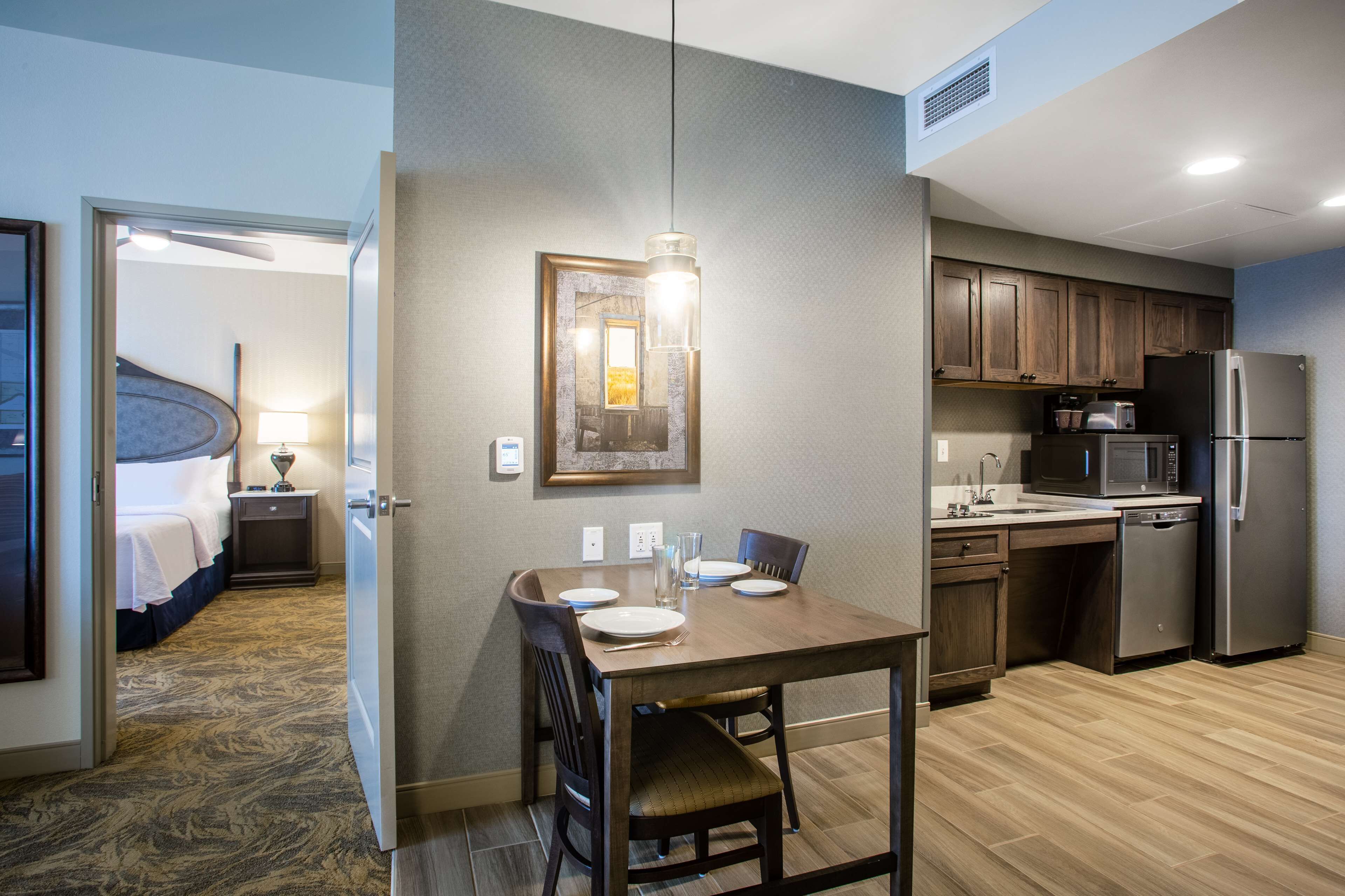 Hotelkamer met een zithoek, kitchenette en een slaapkamer met een gebogen trap.