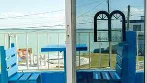 A blue outdoor seating area with benches and a glass door. - Mirador Hotel (Corozal)