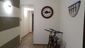 En gang med et ur, en vægmonteret bøjle og cykler.