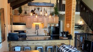 A cozy kitchen with wooden cabinets, a central island, and hanging pendant lights. - HEAVENLY MOUNTAIN RETREAT (Stateline)