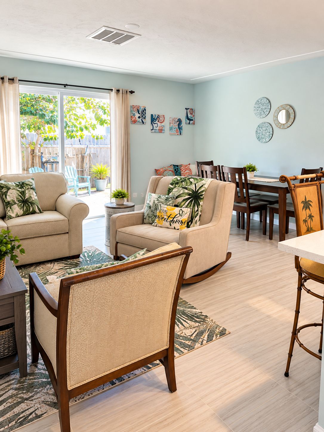 A living room with a sofa, chairs, a dining table, and a view of the outdoors.