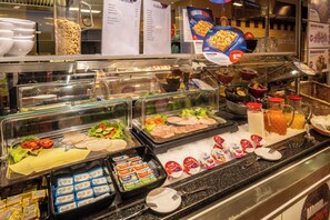A buffet with various food items and condiments.