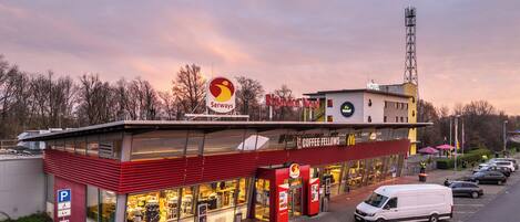 Un hotel Serways con diseño moderno, un área de estacionamiento y un restaurante McDonald's.