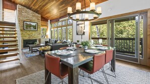 Un comedor espacioso con techo de madera, ventanas amplias y vistas al exterior.