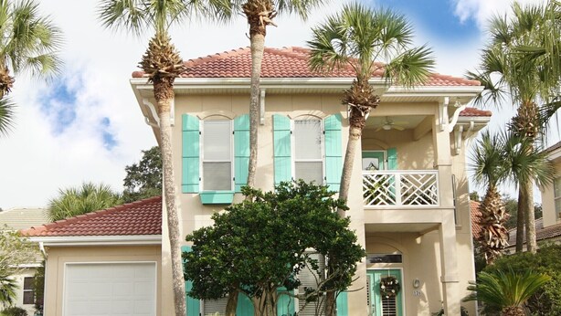 A two-story house with a red-tiled roof, green shutters, and a small balcony. -  Luxury home with sugar white sand beach, family-friendly vacation rental house! (Destin)