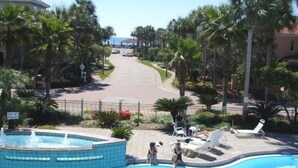 A swimming pool with a fountain, surrounded by palm trees and lounge chairs. -  Luxury home with sugar white sand beach, family-friendly vacation rental house! (Destin)