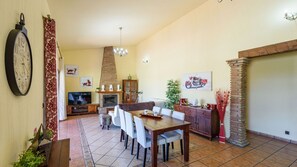 A spacious living area with a fireplace, a dining table, and a TV.
