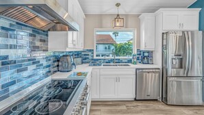 A modern kitchen with a stainless steel range, a dishwasher, and a refrigerator. - Ocean's Paradise is an exquisite 4-bedroom, 3-bathroom retreat nestled within the sought-after enclave of Sombrero Beach (Marathon)