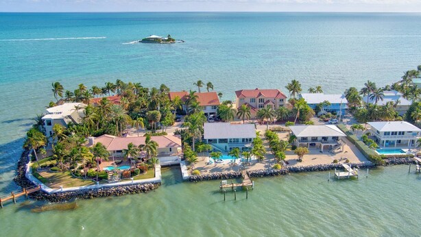 A coastal resort with multiple buildings, a swimming pool, and a dock. - Ocean's Paradise is an exquisite 4-bedroom, 3-bathroom retreat nestled within the sought-after enclave of Sombrero Beach (Marathon)