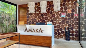 A reception desk with a wooden finish and the name "AMAKA" displayed prominently.