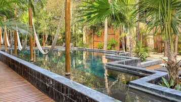 Una piscina al aire libre, sillones reclinables de piscina