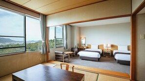 A hotel room with a large window, two beds, a desk, and a chair.