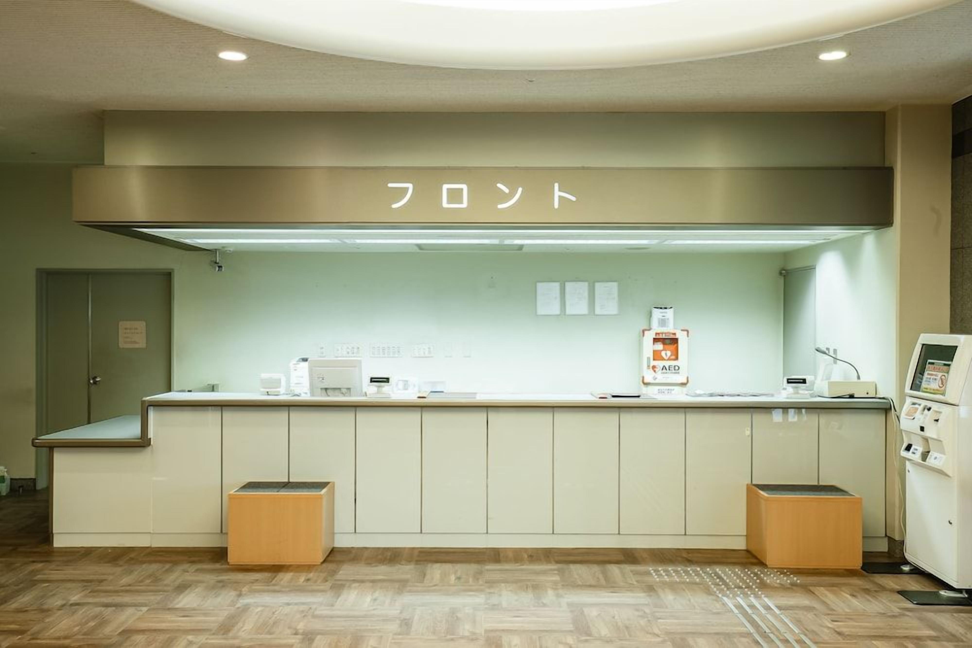 A reception area with a counter, a sign above it, and a machine on the right.