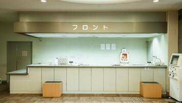 A reception area with a counter, a sign above it, and a machine on the right.