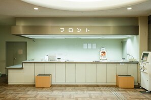 A reception area with a counter, a sign above it, and a machine on the right.