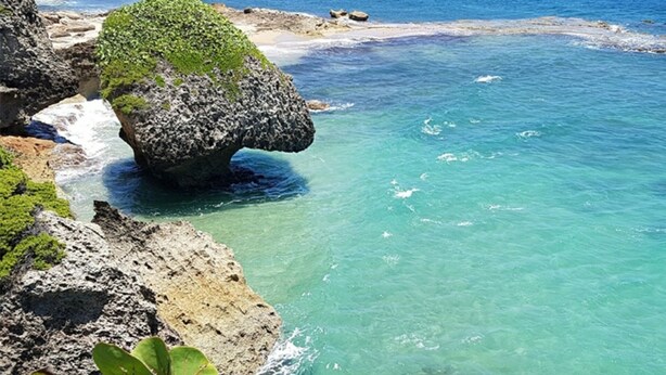 A coastal landscape with clear turquoise waters, rocky formations, and sparse vegetation. - Caribbean getaway aguadilla (Aguadilla Pueblo)