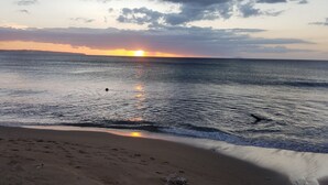 A beach with a sunset, calm sea, and footprints in the sand. - Caribbean getaway aguadilla (Aguadilla Pueblo)