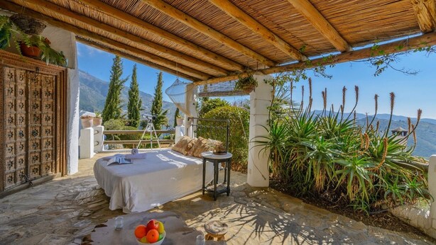 A cozy outdoor bedroom with a bed, a small table, and a view of mountains. - The Hunting Lodge Alcaucín by Ruralidays (Málaga)