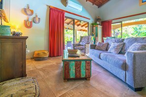 A cozy living room with a sofa, a coffee table, and a wooden cabinet. - Casa de las Mariposas-Where Jungle Meets the Sea (San Buena)